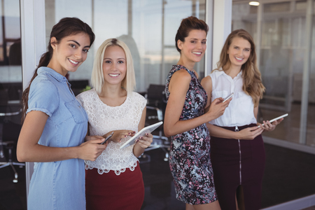 Portrait of smiling business colleagues using digital tablet at creative officeの写真素材