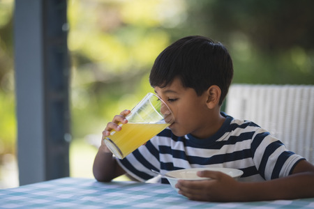 Boy having breakfast while sitting at tableの写真素材