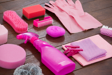 Close-up of pink color cleaning equipment arranged on wooden floorの写真素材