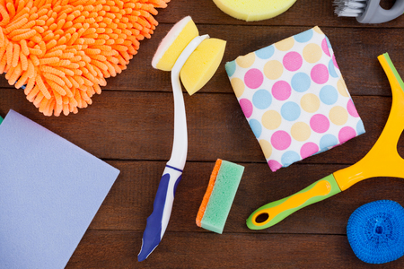 Close-up of various cleaning equipment arranged on wooden floor