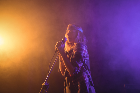 Low angle view of female singer performing in illuminated nightclub