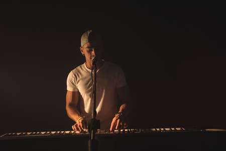 Young male singer playing piano at music concertの写真素材