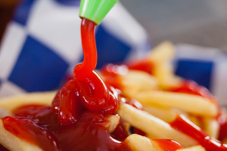 Close-up of ketchup falling on french fries