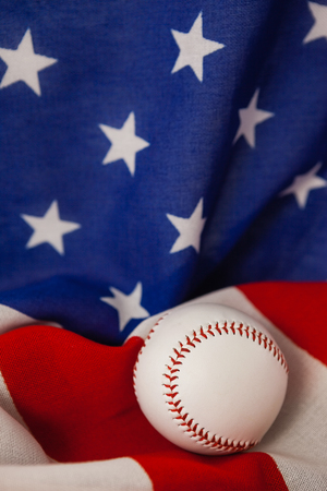 Close-up of baseball ball on American flagの写真素材