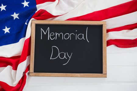 Close-up of slate with text and an American flag on wooden tableの写真素材
