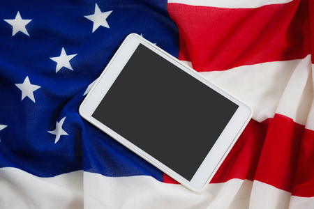 Close-up of digital tablet on an American flagの写真素材