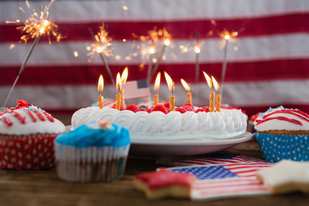 Patriotic 4th of July cake and cupcake arranged on wooden tableの写真素材