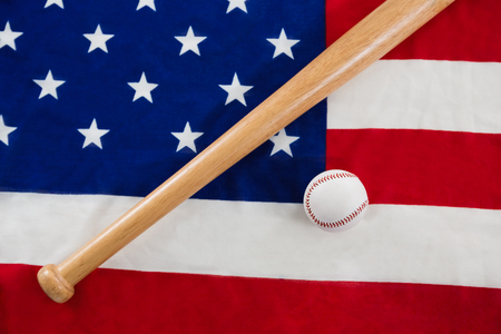 Close-up of baseball and baseball bat on an American flagの写真素材