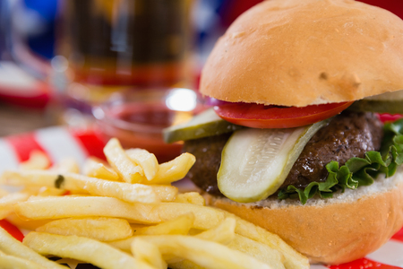 Close-up of burger and french fries on wooden table with 4th July themeの写真素材