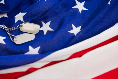 Close-up of dog tags chain on an American flagの写真素材