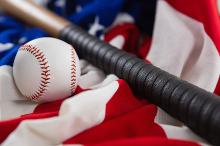 Close-up of baseball and baseball bat on an American flagの写真素材