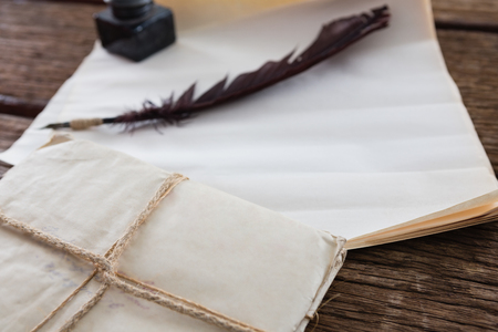 Quill feather, ink pot and legal documents arranged on wooden tableの写真素材