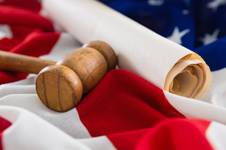 Close-up of gavel and rolled-up document arranged on American flagの写真素材