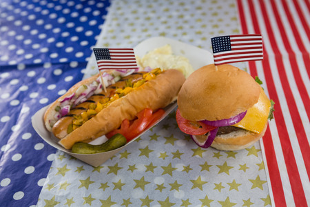 Close-up of burger and hot dog on wooden table with 4th July themeの写真素材