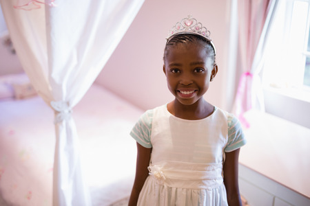 Portrait of smiling girl wearing fairy costume in bedroom at homeの写真素材