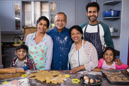 Portrait of smiling multi-generation family standing together in kitchen at homeの写真素材