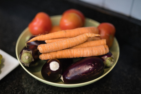 High angle view of vegetables in plate on counter at homeの写真素材
