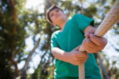 Boy practicing tug of war during obstacle course training in the boot campの写真素材