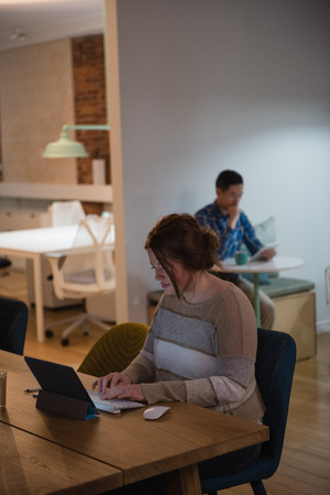Female executive using digital tablet at desk in officeの写真素材
