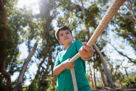 Boy practicing tug of war during obstacle course training in the boot campの写真素材