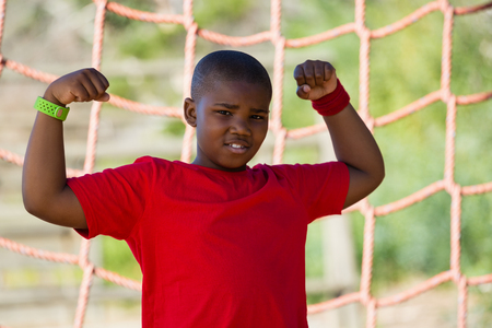 Portrait of boy standing in the boot camp during obstacle course trainingの写真素材