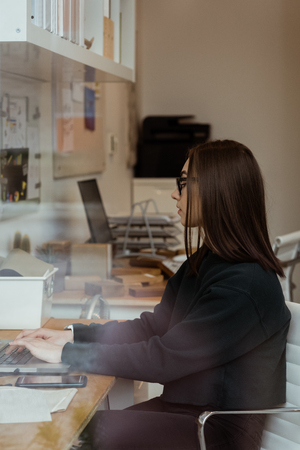 Attentive female executive working on laptop in officeの写真素材