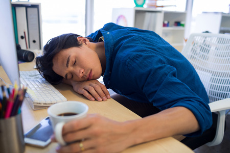 Exhausted male executive resting at his desk in office