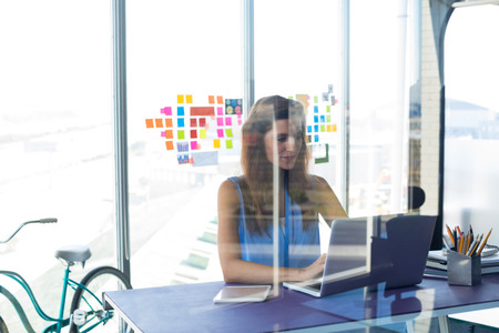 Female executive working over laptop in office