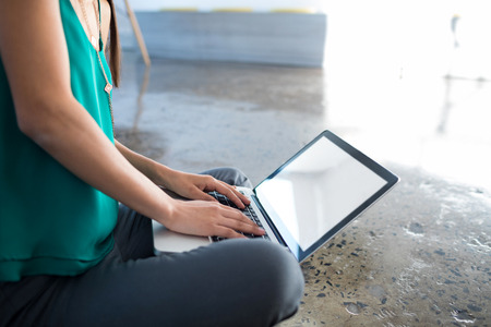 Close-up of female executive using laptop in office
