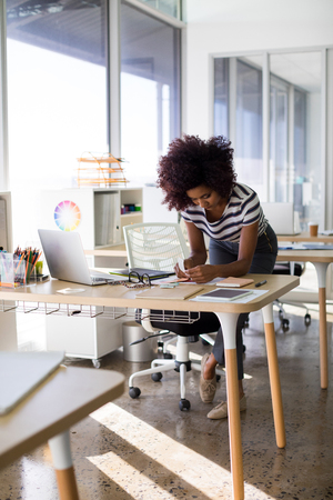 Female executive working at her desk in officeの写真素材