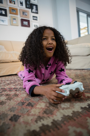Girl playing video game in the living room at homeの写真素材
