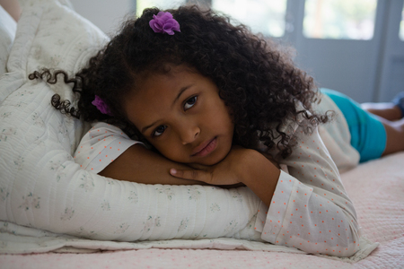 Girl lying on a bed in the bedroom at homeの写真素材