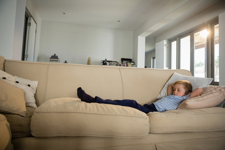 Boy sleeping on sofa in the living room at homeの写真素材