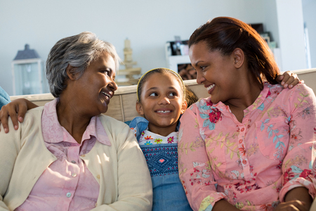 Happy family sitting on sofa in living room at home