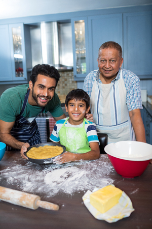 Portrait of happy family preparing food in kitchen at homeの写真素材