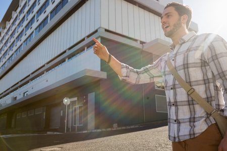 Low angle view of man gesturing while standing on city streetの写真素材