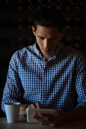 Man using digital tablet in restaurantの写真素材
