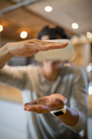 Smiling man using virtual reality headset in restaurantの写真素材