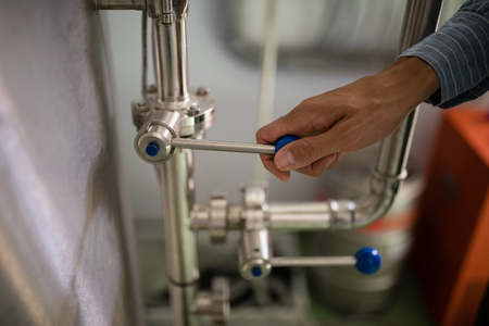 Close-up of manager operating machinery in warehouse of restaurantの写真素材