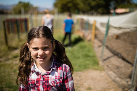 Portrait of smiling girl standing in the ranch on a sunny dayの写真素材
