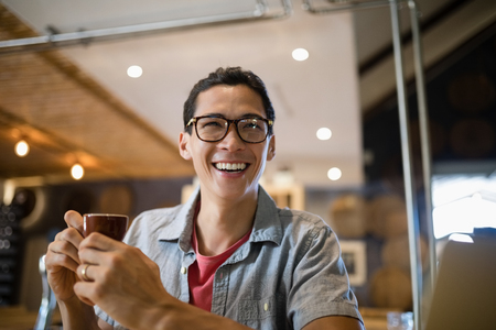Smiling man having coffee in restaurantの写真素材