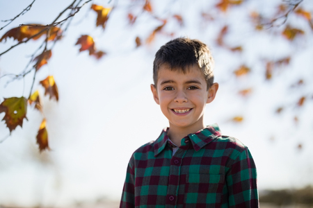 Portrait of smiling boy standing in park on a sunny dayの写真素材