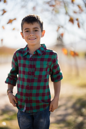 Portrait of smiling boy standing in park on a sunny dayの写真素材