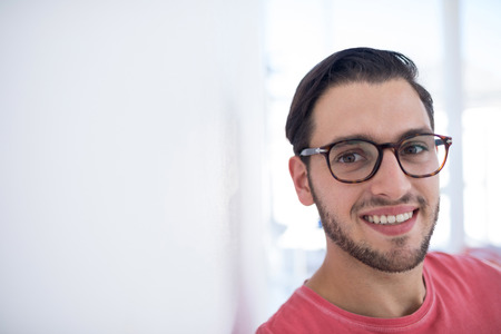 Portrait of male executive leaning on wall in the officeの写真素材