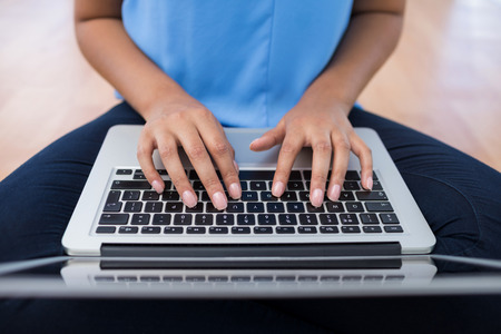 Mid-section of female executive using laptop in the office
