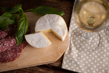 Close up of cheese with meat and wineglass on tableの写真素材