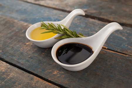 Close up of olive oil in white spoon on wooden tableの写真素材