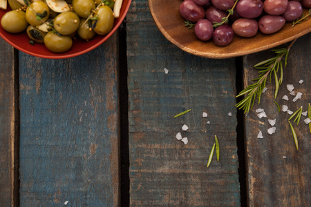 Overhead view of olives in plates on wooden tableの写真素材