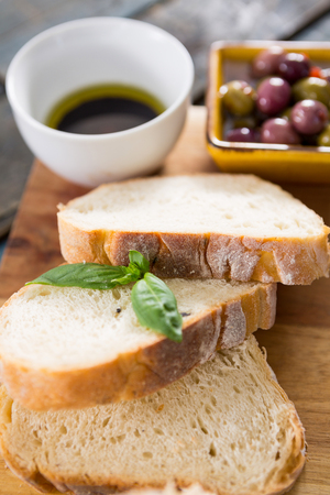 Close-up of bread slices with herbs on chopping boardの写真素材