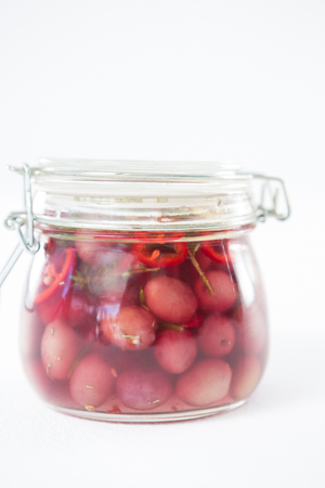 Preservative olives in jar against white backgroundの写真素材